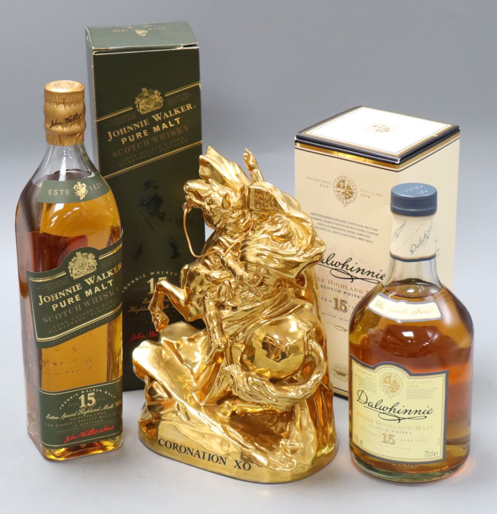 An ornate bottle of Coronation XO cognac and two bottles of whisky